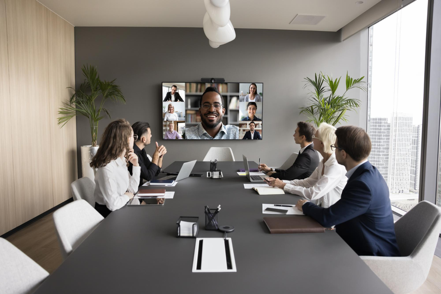 Sala de reunião corporativa equipada com barra de videoconferência